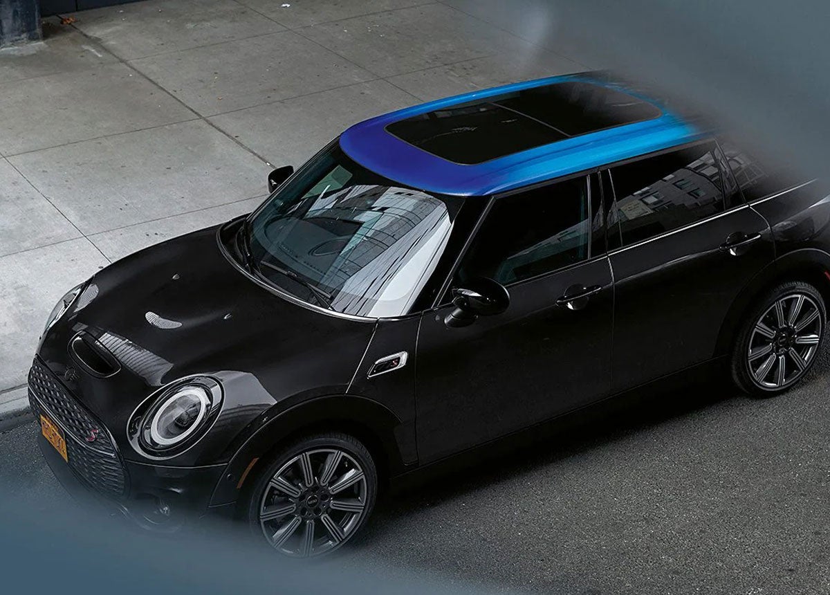 View from above of a black MINI Clubman that is parked on a city street.