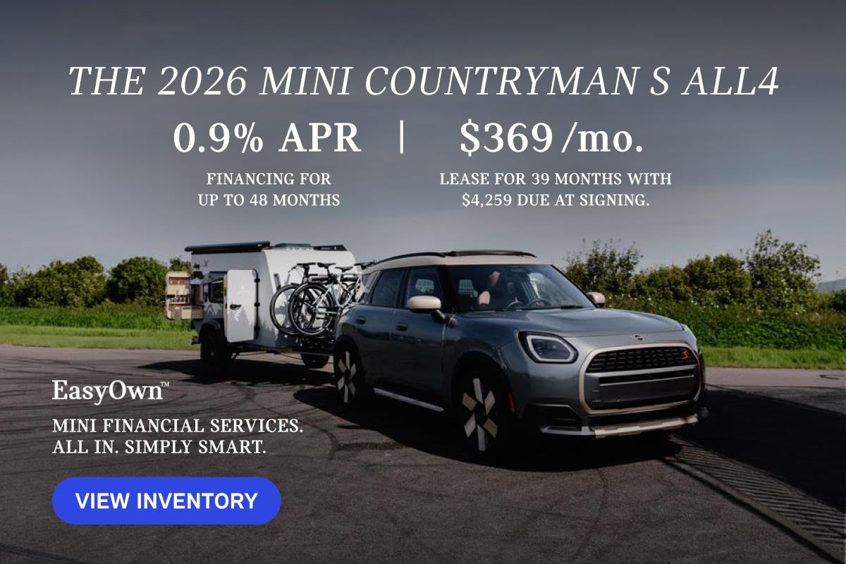 Grey MINI Countryman parked with bicycles and trailer in tow.