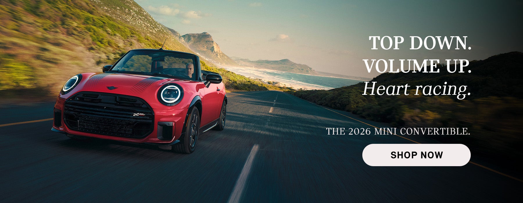 Red MINI convertible driving along a coastal road with mountains and ocean in the background, with advertisement text