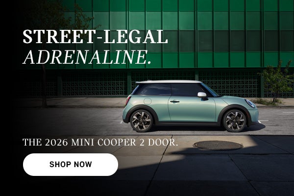 Mint green MINI Cooper 2-door parked on a city street with building backdrop, with ad text promoting the 2026 model 