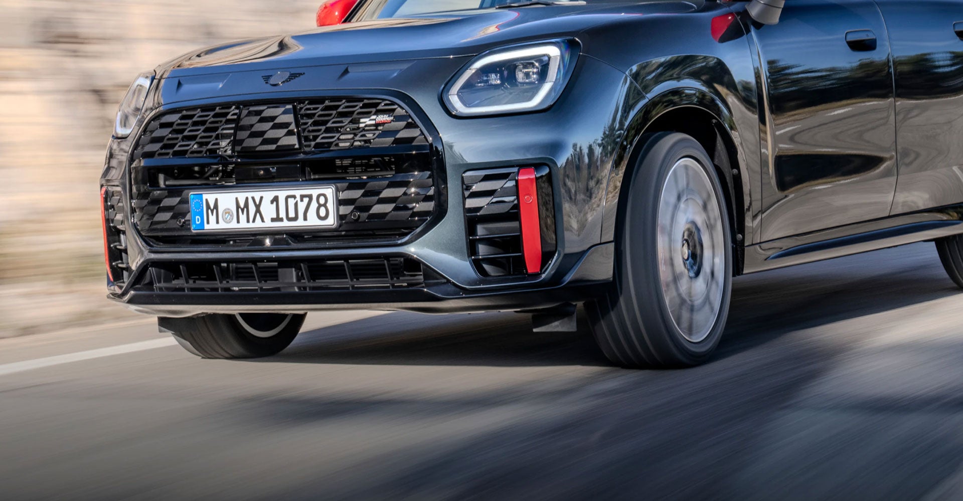 An angled view of the MINI JCW Countryman ALL4 as it drives down a road.