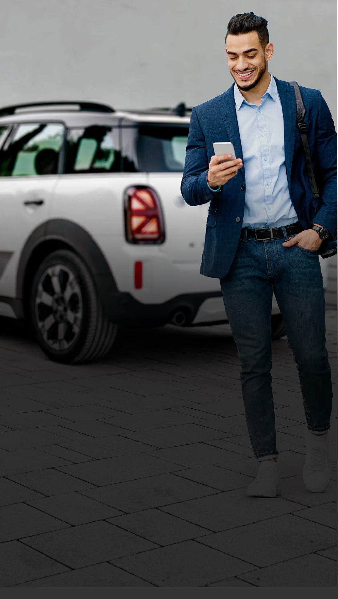 A man walks away from his parked MINI while on the phone