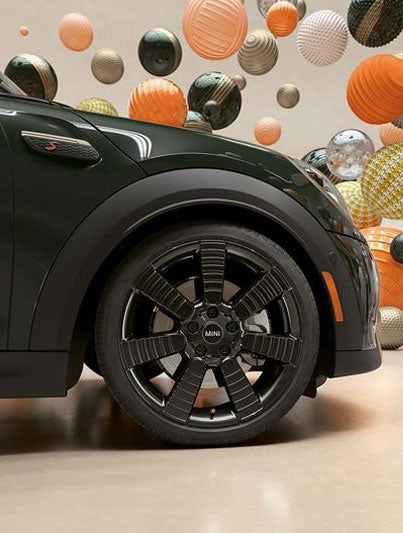 Closeup of the exclusive 18” pulse spoke black wheels on a MINI Resolute Edition, in a CGI world filled with floating, multi-color and multitexture balls.