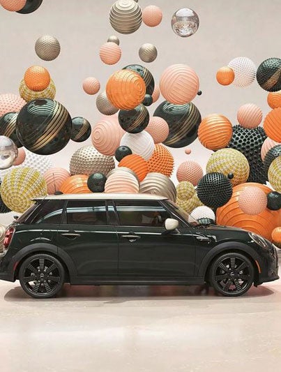 Side view of a MINI Resolute Edition, in a CGI world filled with floating, multi-color and multi-texture balls.
