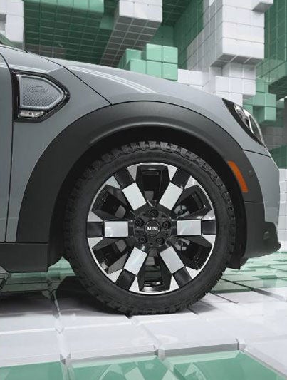 Closeup of the exclusive 18” Untamed spoke 2-tone wheels on a MINI Countryman Untamed Edition, in a CGI world made up of 3D, Tetris-like boxes.