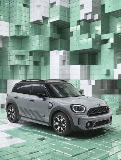 Three-quarter top view of a MINI Countryman Untamed Edition, showcasing its piano black exterior details, and black roof and mirror caps, in a CGI world made up of 3D, Tetris-like boxes.